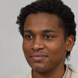 Joyful black young-adult male with short  brown hair and brown eyes