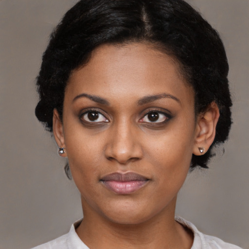 Joyful black young-adult female with short  black hair and brown eyes
