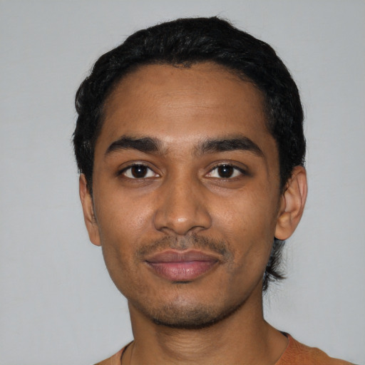 Joyful black young-adult male with short  black hair and brown eyes