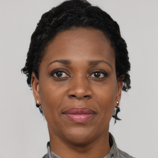 Joyful black adult female with short  black hair and brown eyes