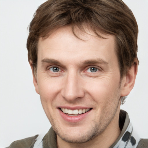 Joyful white young-adult male with short  brown hair and grey eyes