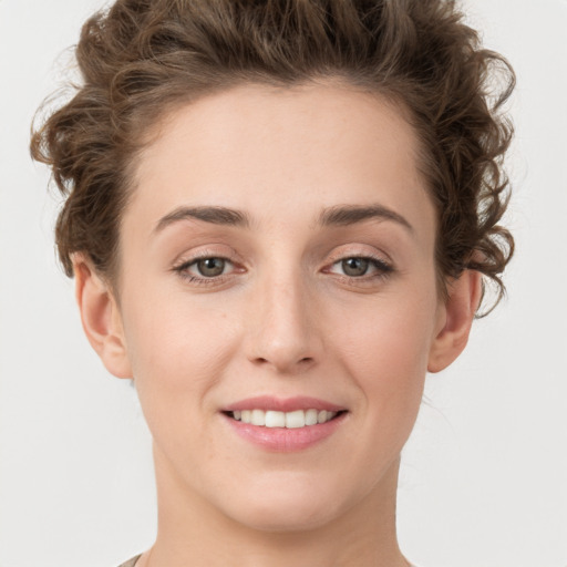 Joyful white young-adult female with short  brown hair and green eyes