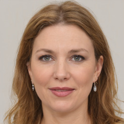 Joyful white adult female with long  brown hair and grey eyes