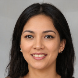 Joyful latino young-adult female with long  brown hair and brown eyes