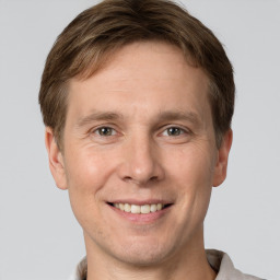 Joyful white young-adult male with short  brown hair and grey eyes