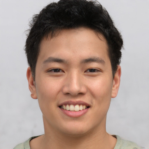 Joyful asian young-adult male with short  brown hair and brown eyes