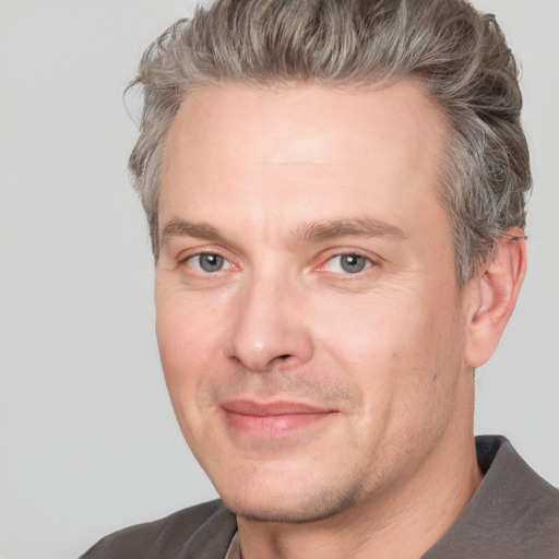 Joyful white adult male with short  brown hair and grey eyes