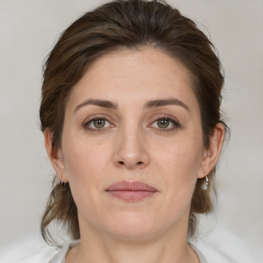 Joyful white young-adult female with medium  brown hair and green eyes