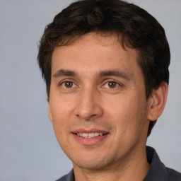 Joyful white adult male with short  brown hair and brown eyes
