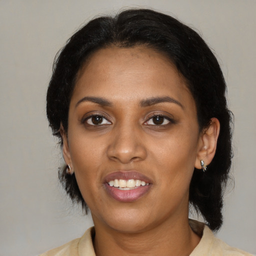 Joyful black young-adult female with medium  black hair and brown eyes