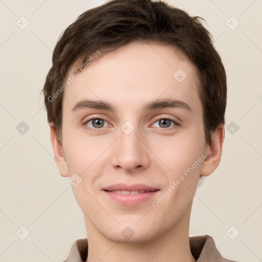 Joyful white young-adult male with short  brown hair and grey eyes