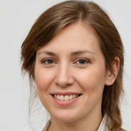 Joyful white young-adult female with medium  brown hair and grey eyes