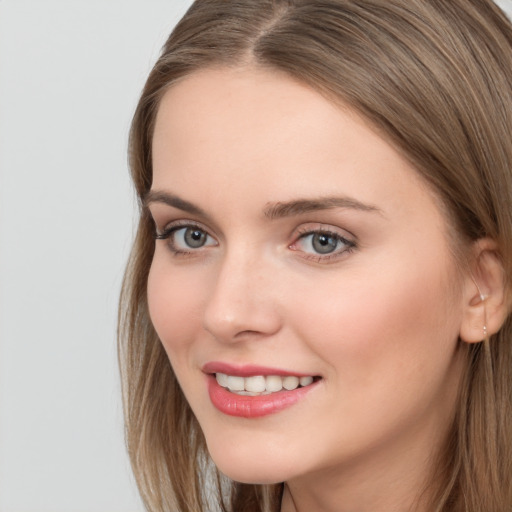 Joyful white young-adult female with long  brown hair and grey eyes