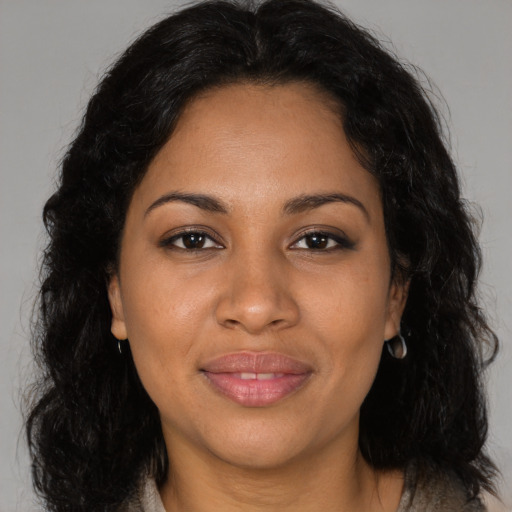 Joyful latino adult female with long  brown hair and brown eyes