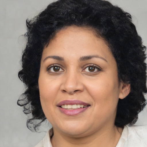 Joyful latino adult female with medium  brown hair and brown eyes