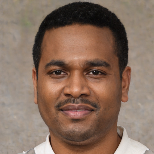 Joyful black young-adult male with short  black hair and brown eyes