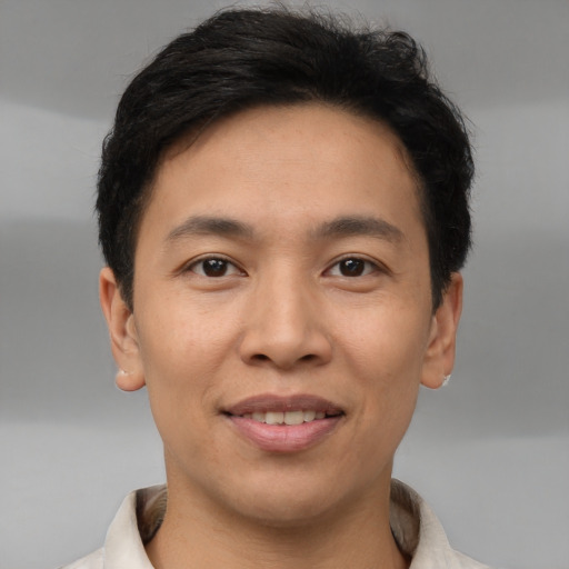 Joyful asian young-adult male with short  brown hair and brown eyes