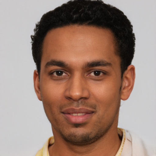 Joyful latino young-adult male with short  black hair and brown eyes