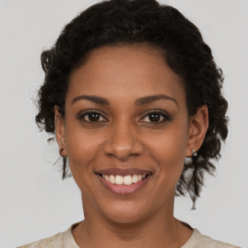Joyful black young-adult female with short  brown hair and brown eyes