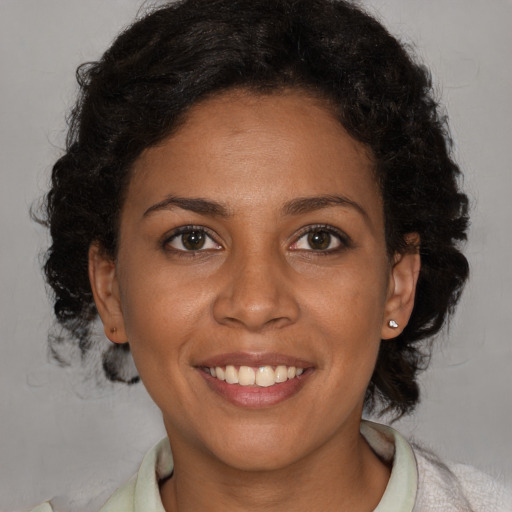 Joyful black young-adult female with short  brown hair and brown eyes