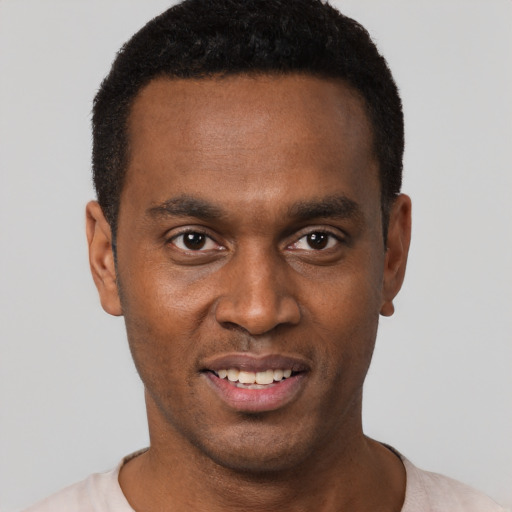Joyful black young-adult male with short  black hair and brown eyes