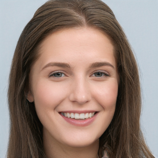 Joyful white young-adult female with long  brown hair and grey eyes