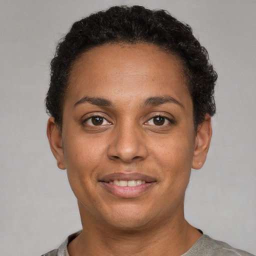 Joyful black adult female with short  black hair and brown eyes
