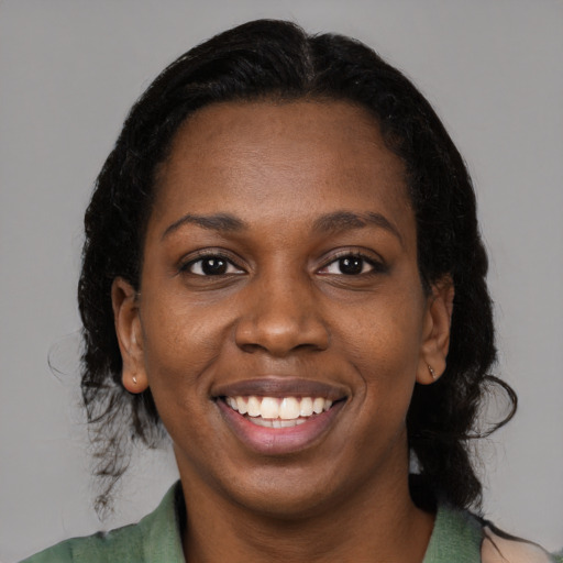 Joyful black young-adult female with medium  brown hair and brown eyes