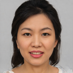 Joyful asian young-adult female with medium  brown hair and brown eyes