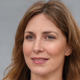 Joyful white adult female with long  brown hair and brown eyes