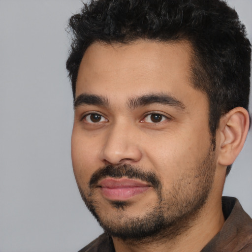 Joyful latino young-adult male with short  black hair and brown eyes