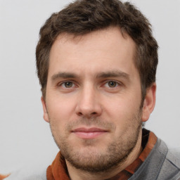 Joyful white young-adult male with short  brown hair and grey eyes