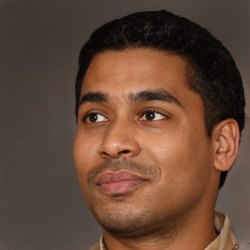 Joyful latino young-adult male with short  black hair and brown eyes