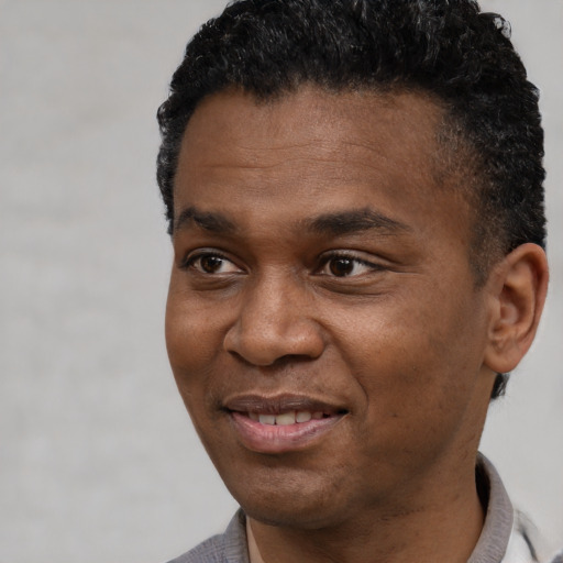 Joyful black young-adult male with short  black hair and brown eyes