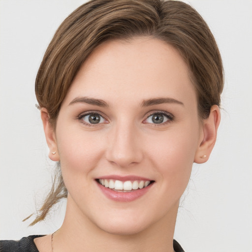 Joyful white young-adult female with medium  brown hair and grey eyes