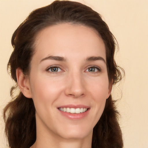 Joyful white young-adult female with long  brown hair and brown eyes