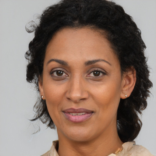 Joyful latino adult female with medium  brown hair and brown eyes