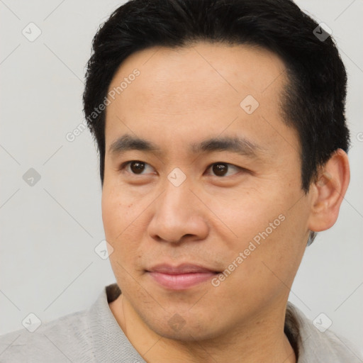 Joyful asian young-adult male with short  brown hair and brown eyes