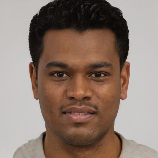 Joyful black young-adult male with short  black hair and brown eyes