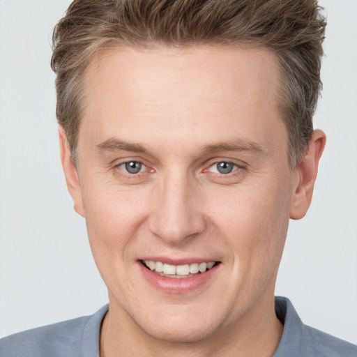 Joyful white adult male with short  brown hair and grey eyes