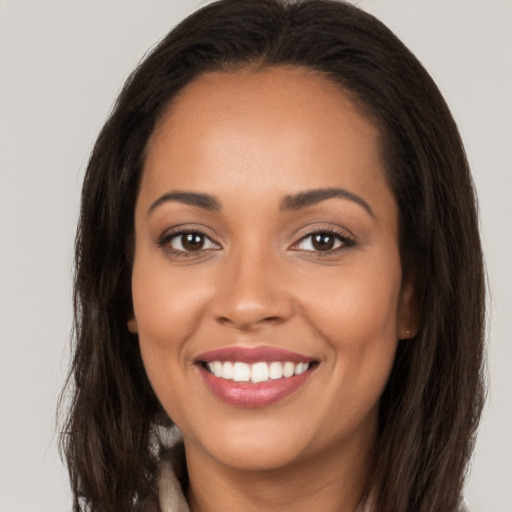 Joyful latino young-adult female with long  brown hair and brown eyes