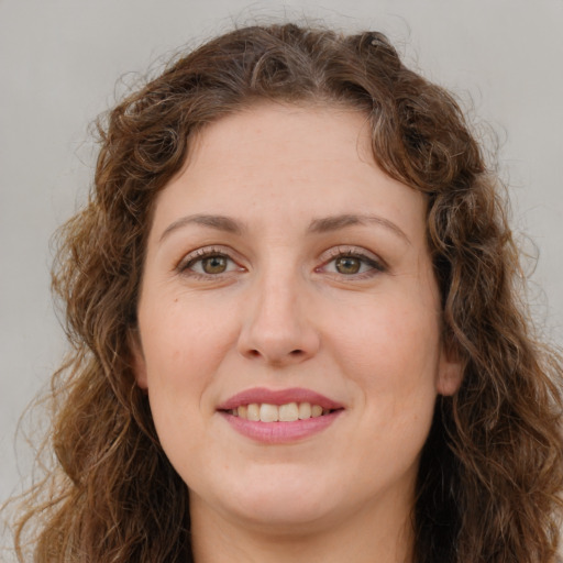 Joyful white young-adult female with long  brown hair and green eyes