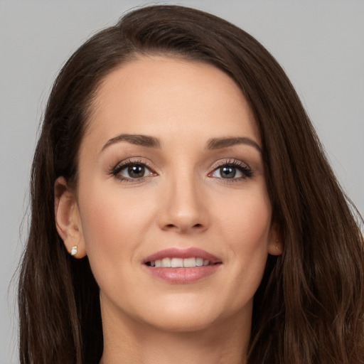 Joyful white young-adult female with long  brown hair and brown eyes