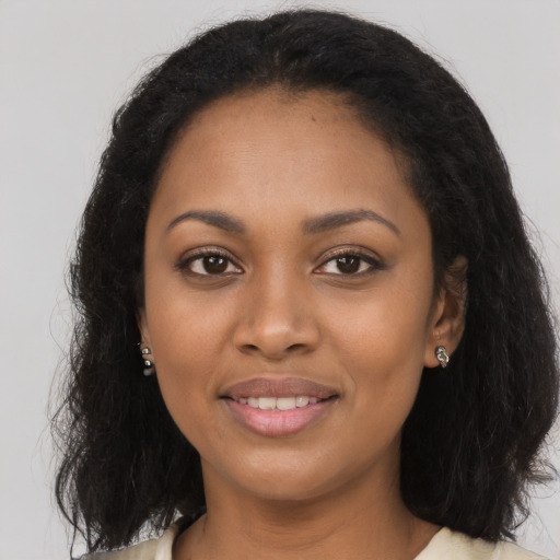 Joyful black young-adult female with long  black hair and brown eyes