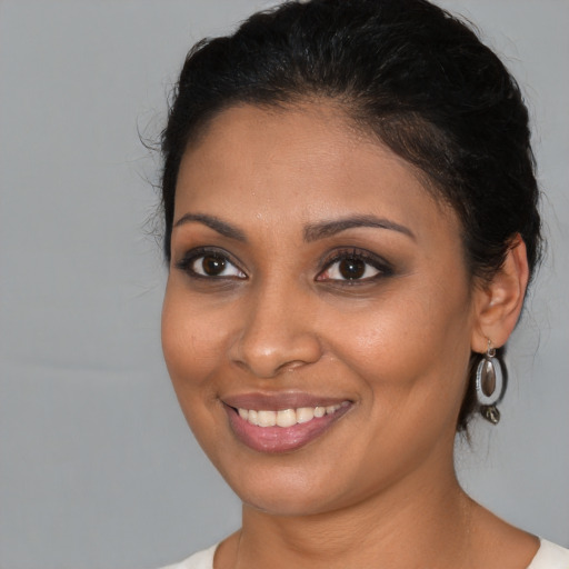 Joyful black young-adult female with medium  brown hair and brown eyes