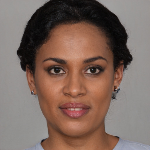 Joyful black young-adult female with short  black hair and brown eyes