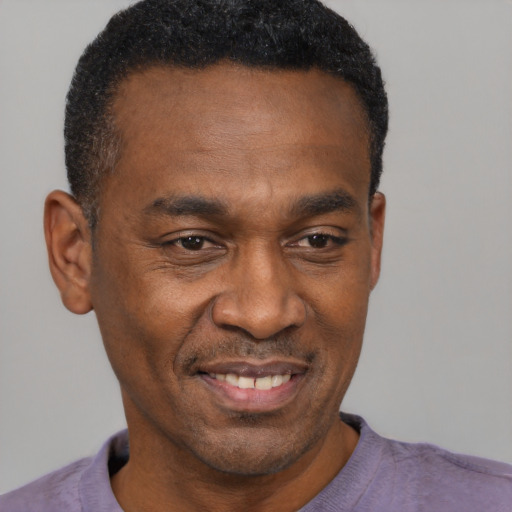 Joyful black adult male with short  black hair and brown eyes