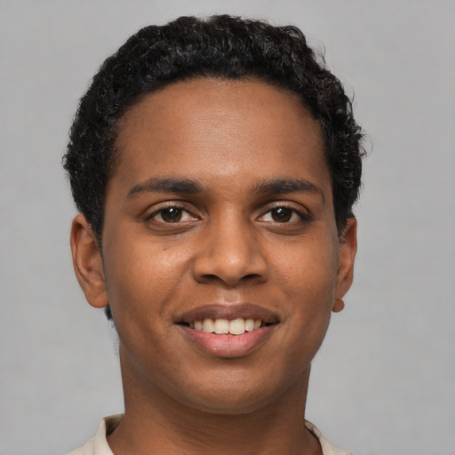 Joyful black young-adult male with short  brown hair and brown eyes