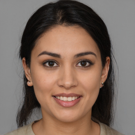 Joyful latino young-adult female with medium  brown hair and brown eyes