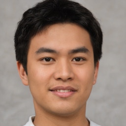 Joyful asian young-adult male with short  brown hair and brown eyes